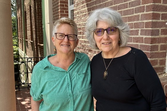 photo of two people, building in background, day