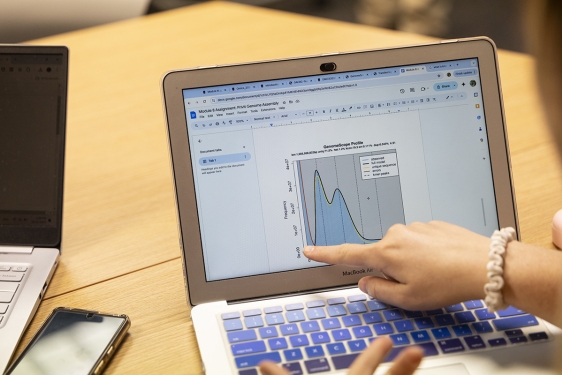 photo of hand pointing at laptop computer
