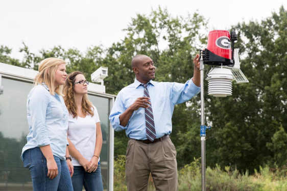 photo of man with student son rooftop weather station