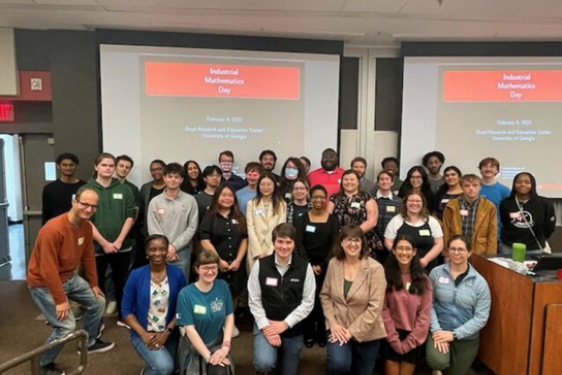 group photo of people, screen in background