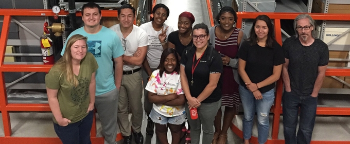 Photo of ten people in a warehouse interior