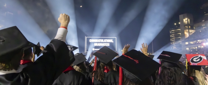 photo of people in caps and gowns, light beams