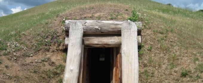 photo of mound lodge entrance, with grass and cloudy skies