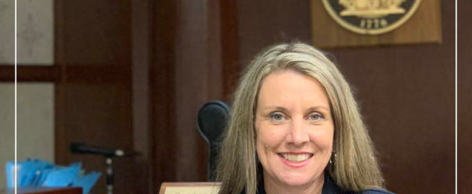 photo of woman in courtroom with state seal and red graphic