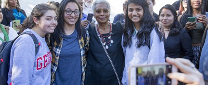 woman with students posing for photos