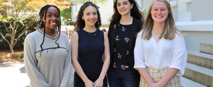 photo of four women, outdoors, building in background