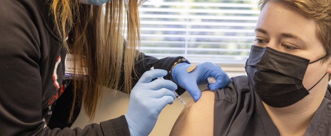 photo of nurse administering vaccination to woman