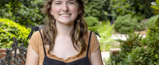 photo of woman, outdoors with gardens in background