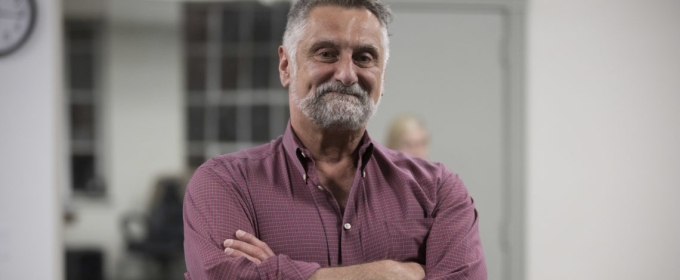 Photo of man indoors, arms folded