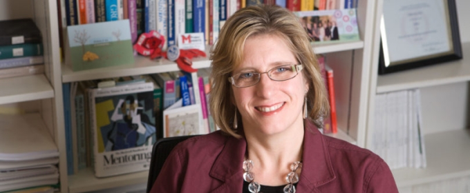 photo of woman sitting in front of bookshelves