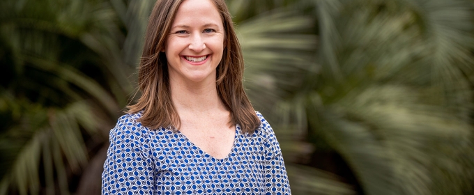 photo of woman with palm fronds in background 