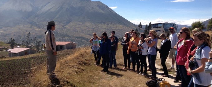 photo. of students with instructor, mountains and village in background