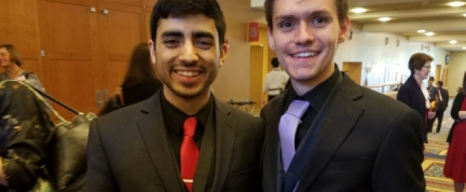 two men in a lobby with medals