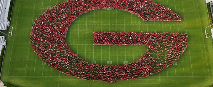 drone aerial photo of people making letter G in stadium