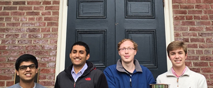 four students in front of Phi Kappa door