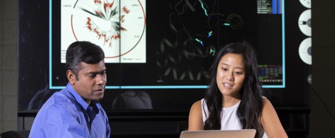 photo of two people seated looking at laptop