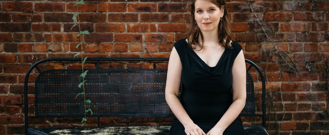 photo of woman sitting on a bench in front of brick wall