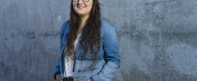 photo of woman standing against concrete wall