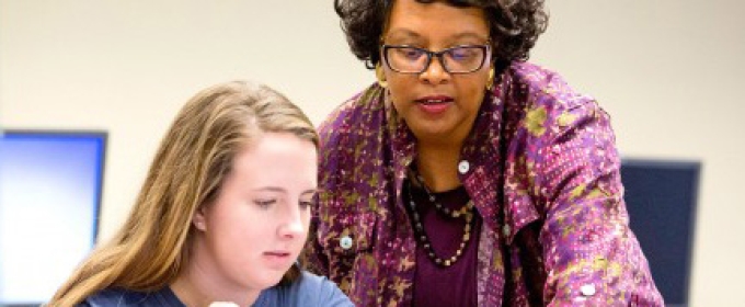 professor with student on computer 