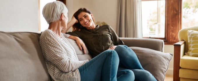 photo of two women talking on a couch