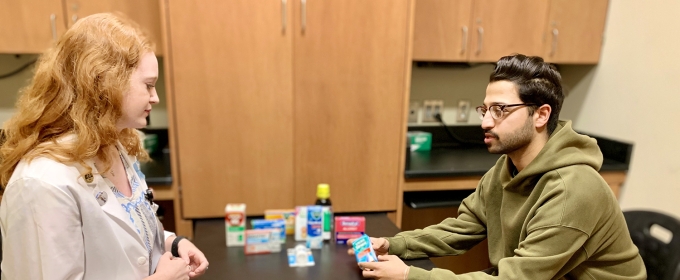photo of two people at table with medicinal products