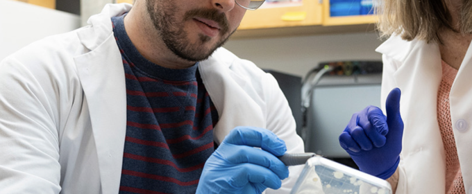 photo of two people in lab with samples, rubber gloves