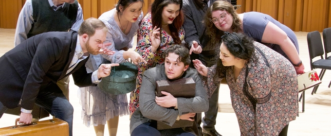 photo of eight people on a stage with suitcases