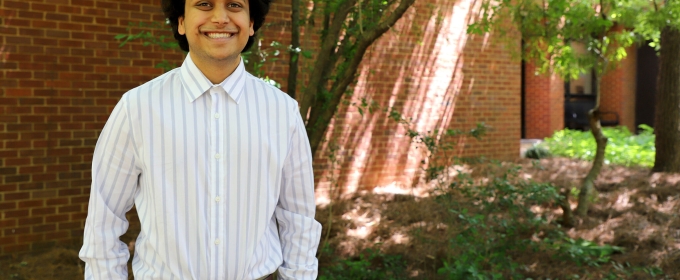 photo of man, next to brick wall and tree