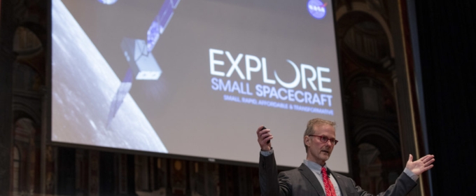 photo of man giving talk in front of screen