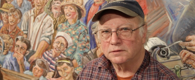 photo of man in front of mural