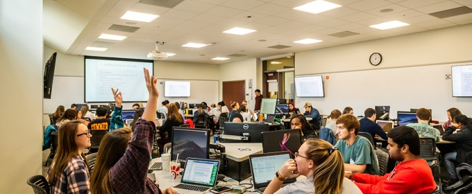 photo of people in classroom, with computers and projection screen