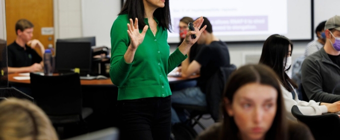 photo of woman, with students at computers