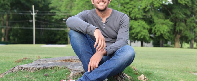 photo. of man sitting outside on tree stump