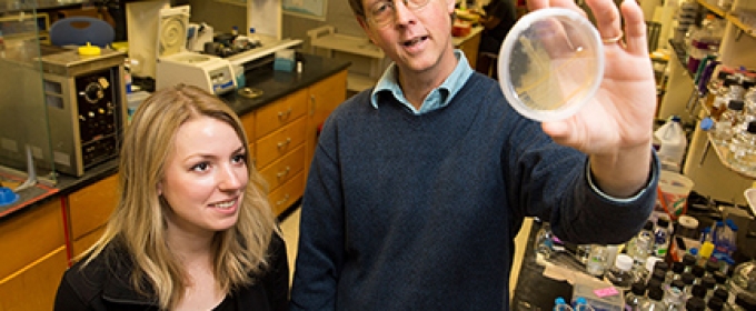 man and student in lab with petri dish