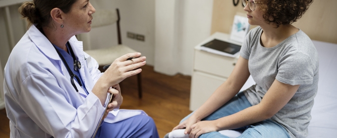 photo of doctor and young patient talking