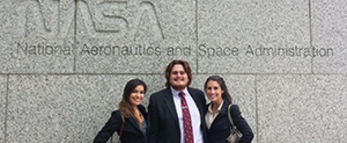 three students in front of NASA sign