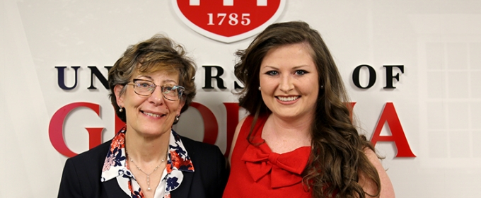 photo of two women standing in front of UGA logo