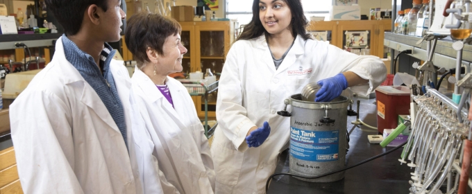 photo of three people in laboratory, with white lab coats