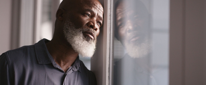 photo of man leaning against window 