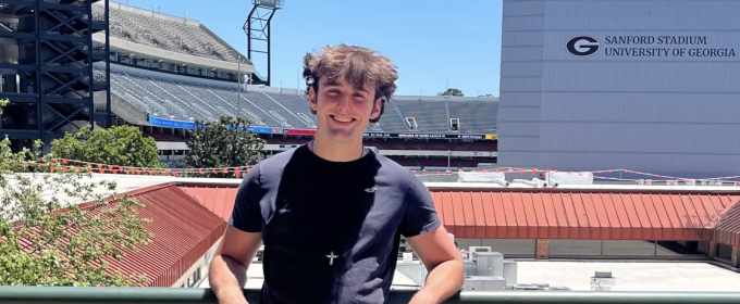 photo of man, stadium in background.