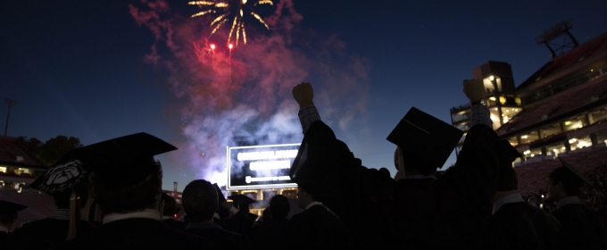 photo with fireworks and silhouette of graduate