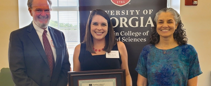 photo of three people, with banner and window