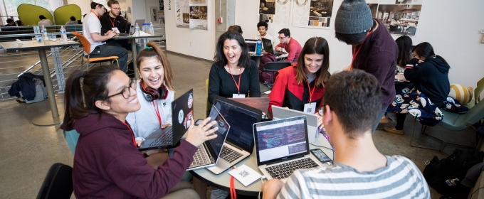 photo of people around a table with laptop computers