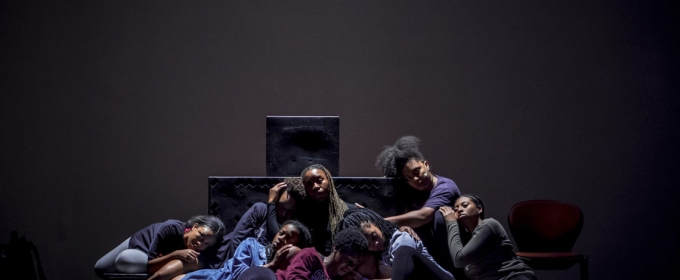 photo of people sitting close together on a darkened stage