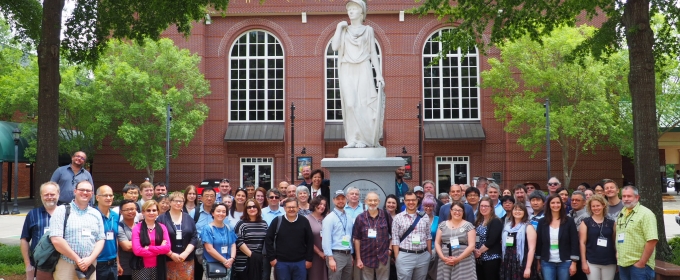 photo of large group of people with statue outdoors