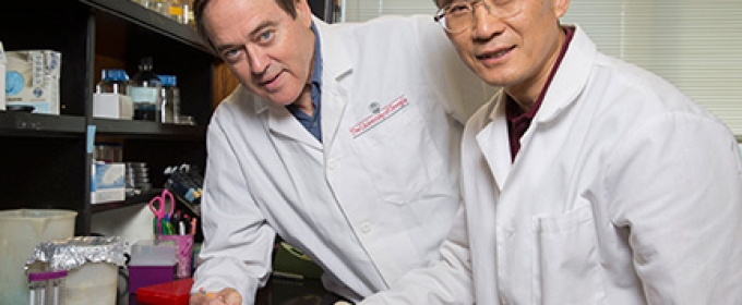 two men in a lab with white coats