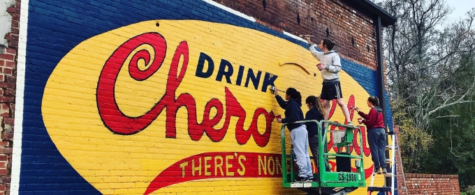 photo of students with lift, painting mural