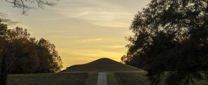 photo of earth mound, covered with grass, twilight