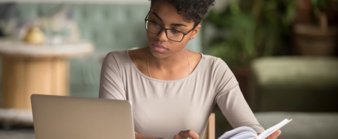 photo of woman with book and laptop