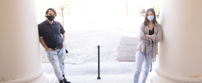 photo of two people leaning against columns, day